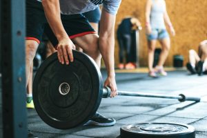 Focused weightlifting session in a gym with diverse athletes participating indoors.
